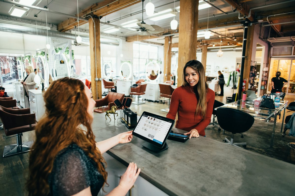 Cashier taking an order on a tablet POS at a café counter